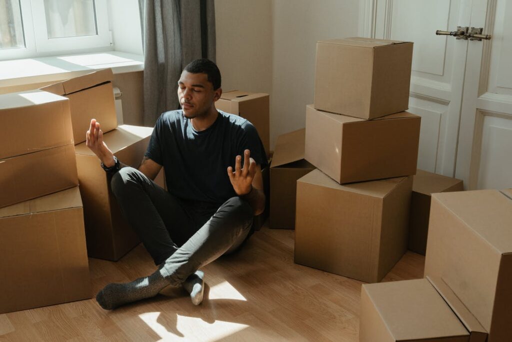 man sitting in front of boxes